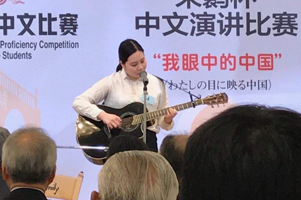 漢語橋杯で 2等賞となった須貝さんは、ギターの弾き語りで中国語の歌を披露してくれました