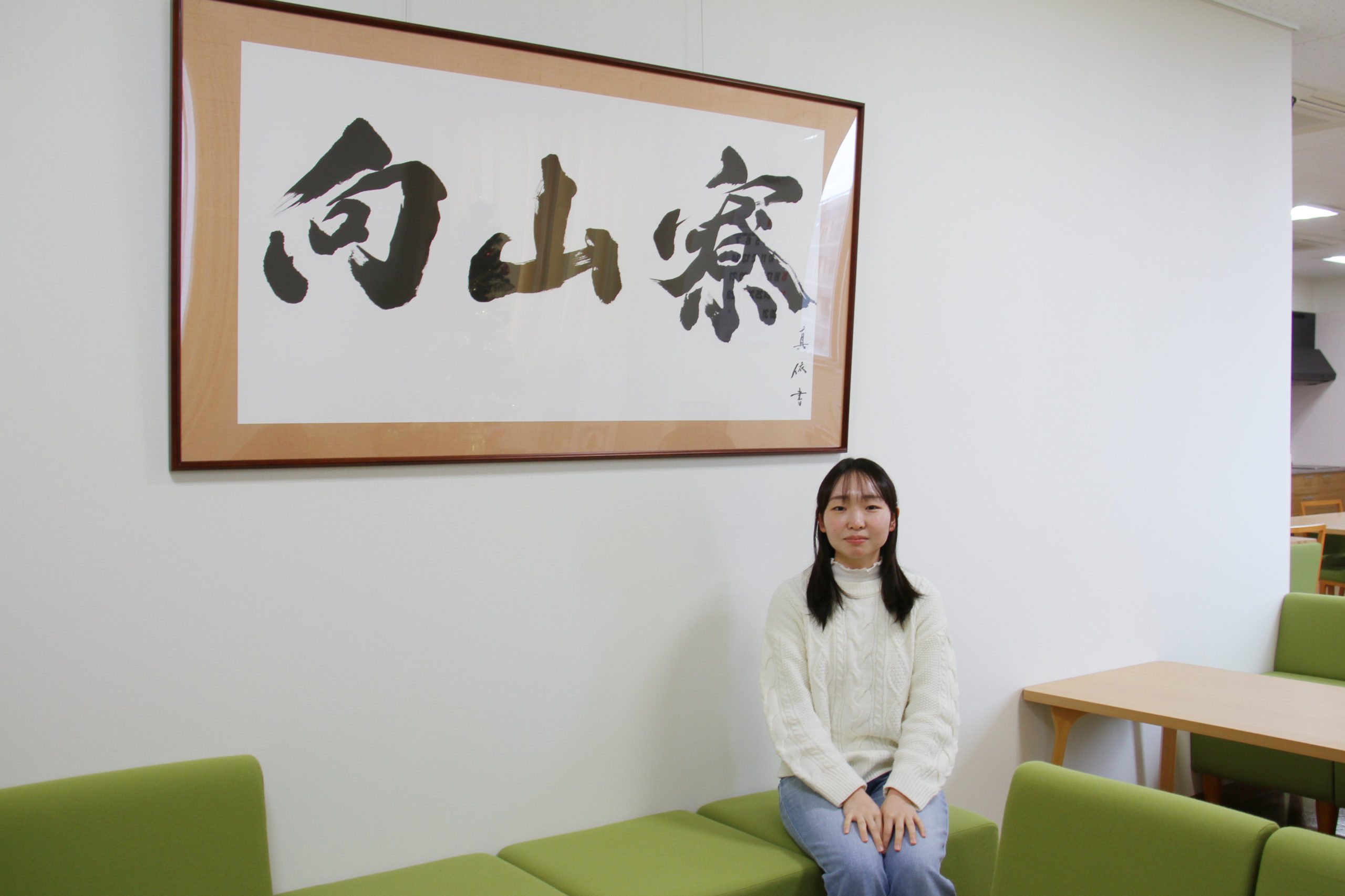 学生たちがくつろぐコミュニティスペースに飾られた「向山寮」の掛軸