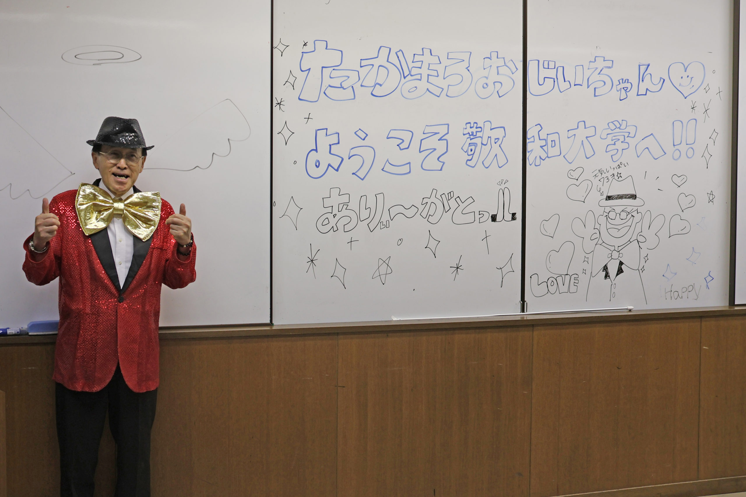 学生が書いたウェルカム・メッセージの前でポーズ！