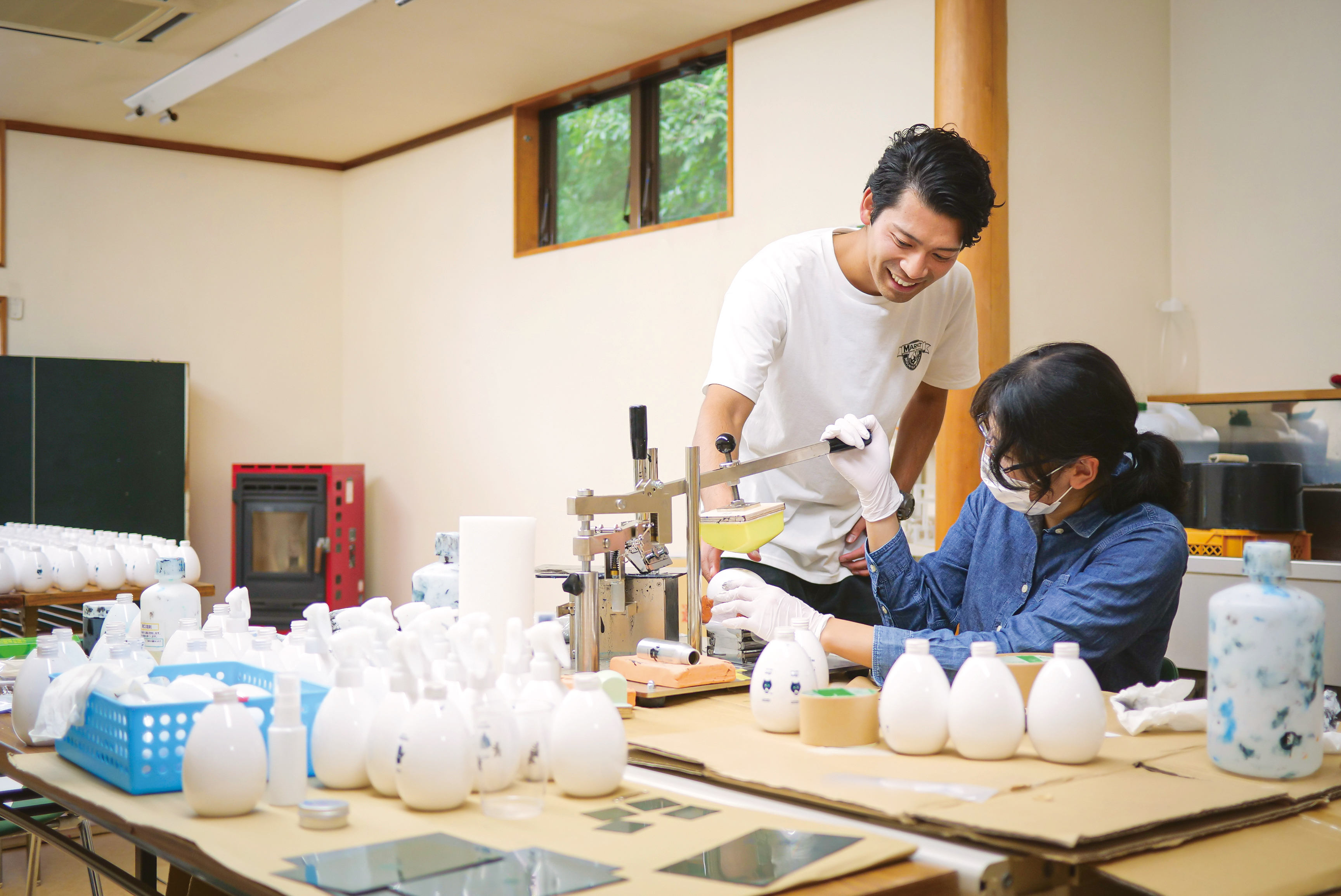 化粧品パッケージへのスタンプを指導する木津さん