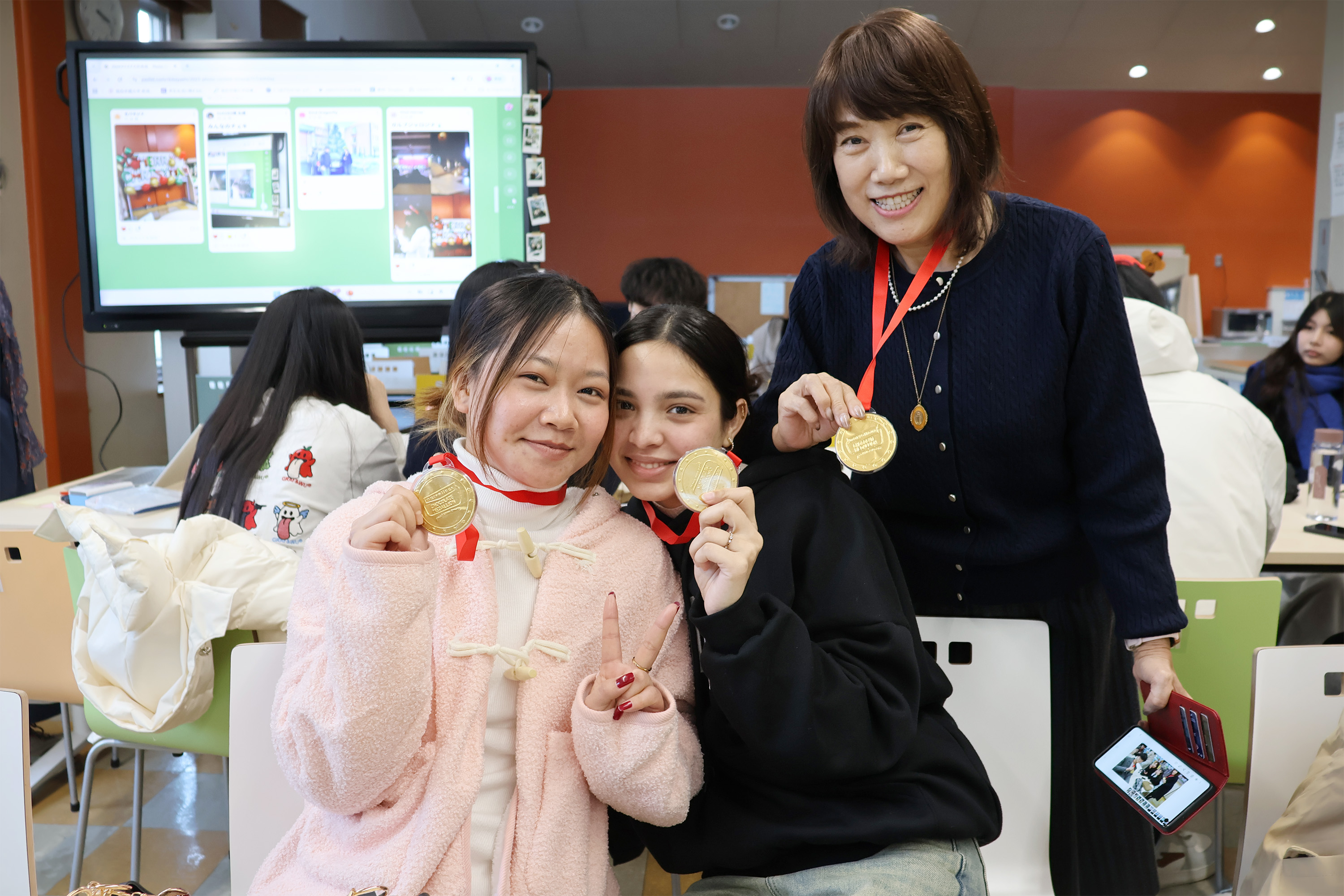 フォトコンテストで入賞した学生と先生（右、房先生）