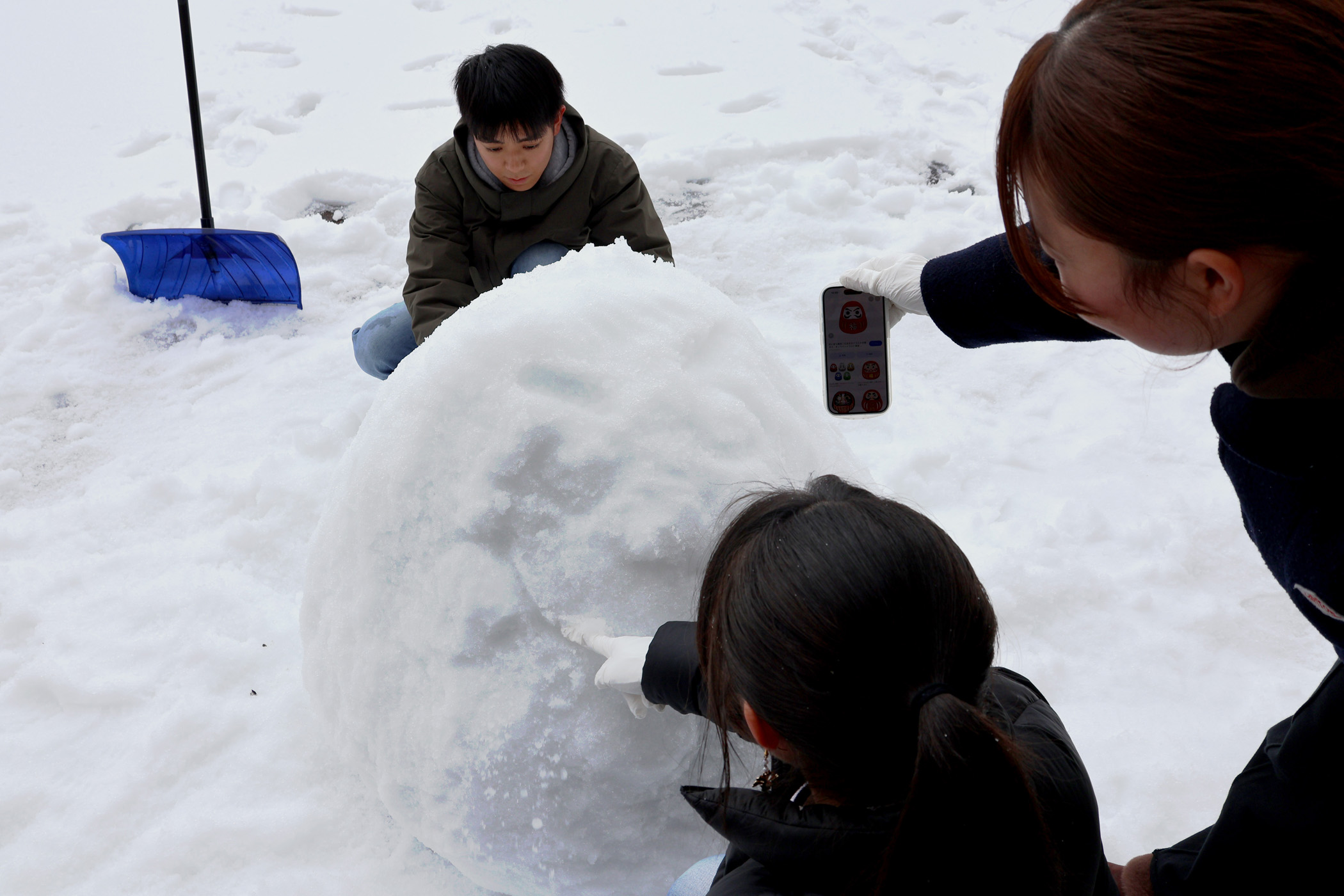 スマートフォンで画像を確認しながら、雪像を整えます。