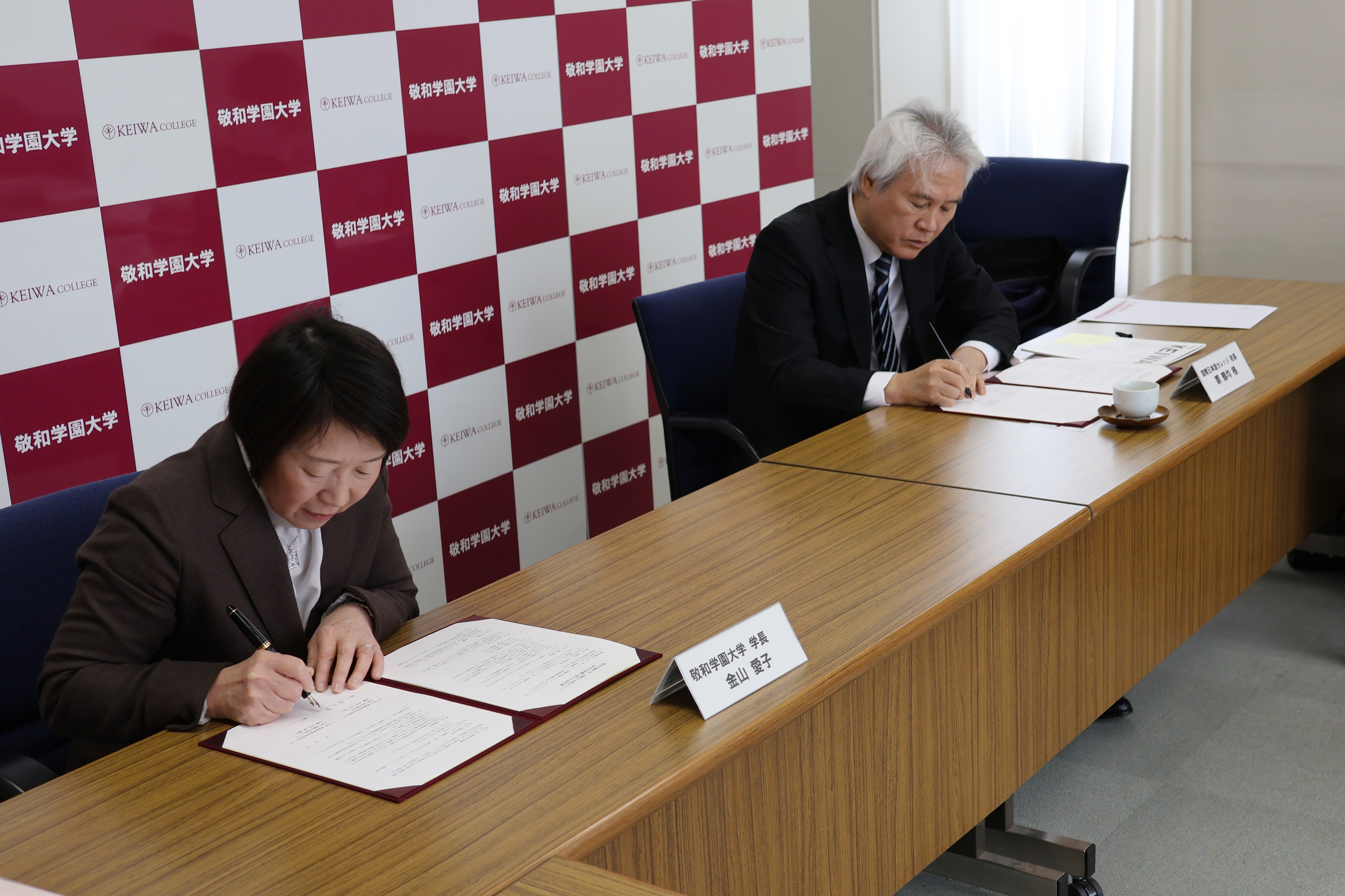 協定書にサインする金山愛子学長と鄭鶴均学校長