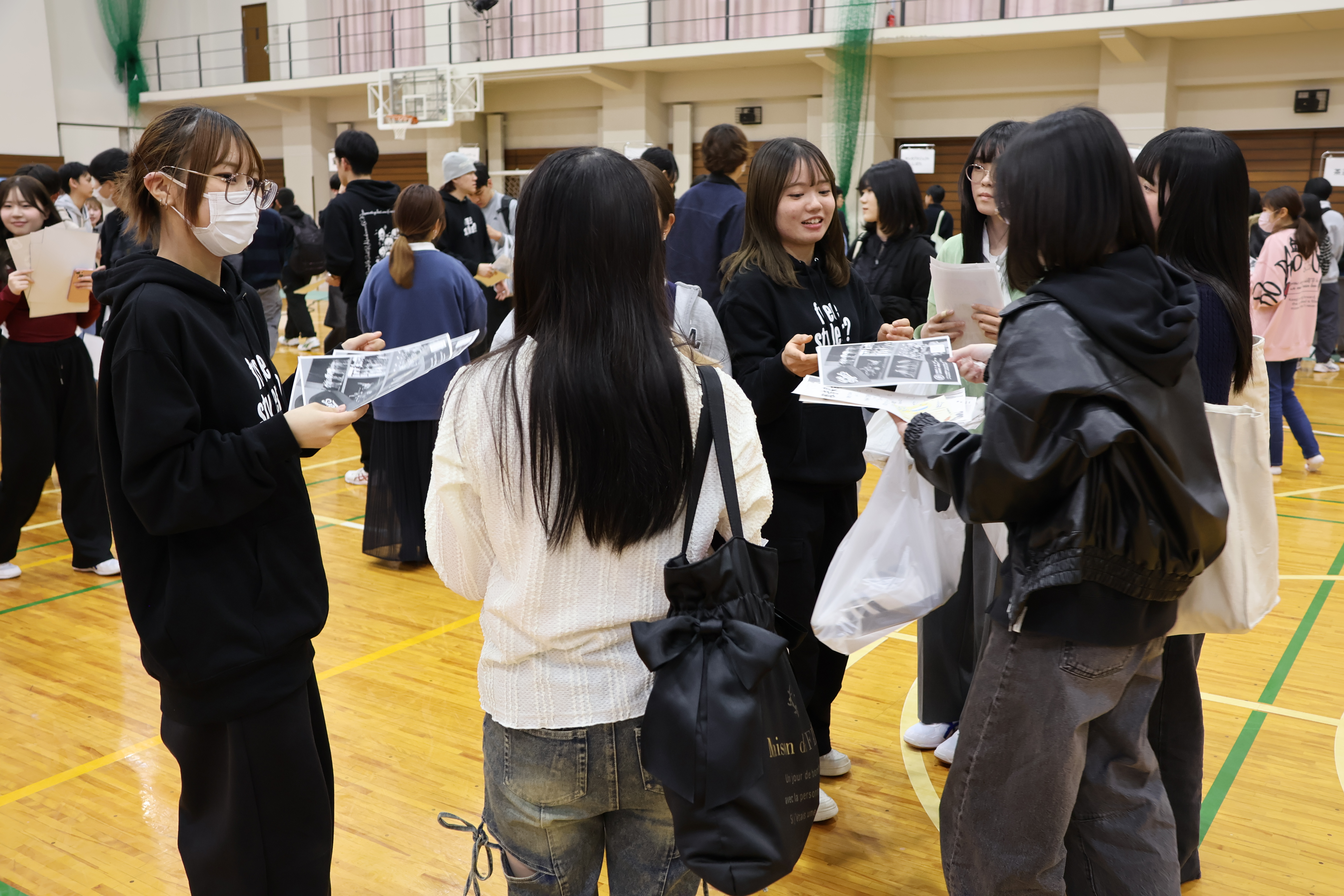先輩たちの勧誘を笑顔で聞く新入生たち